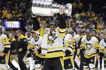 Pittsburgh Penguins captain Sidney Crosby hoisting the Stanley Cup.