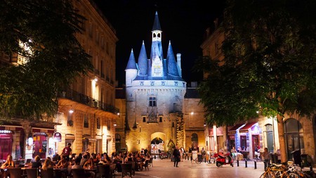 Port Cailhau Bordeaux France at night with busy restaurants in square