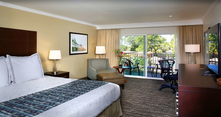 A room with a bed, television and access to an outdoor space at Best Western Plus Garden Court Inn