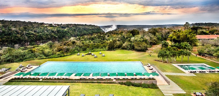 Garden with soft seating, shaded seating, water fountain and forest views at Gran Meliá Iguazú