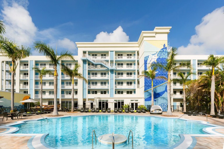 Large pool with hotel building in background and large ocean-themed mural at 24 North Hotel in Key West, Florida