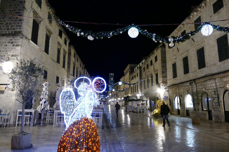 Christmas lights illuminate a street in Dubrovnik at night