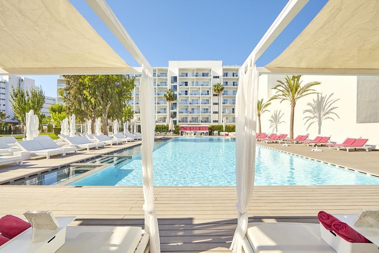 An outdoor pool at Hotel Astoria Playa, Alcudia, surrounded by sun loungers