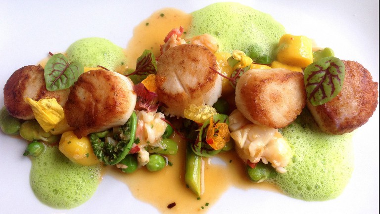 Seared day boat scallops with saffron gnocchi, poached lobster, and early Spring vegetables at Troquet