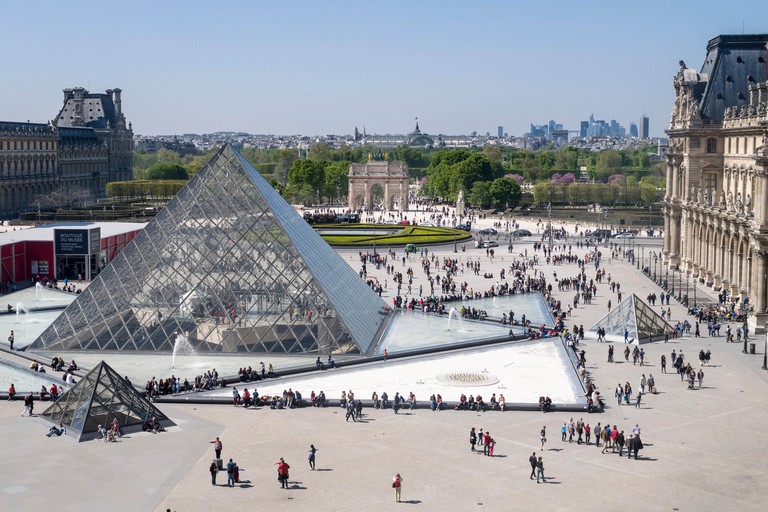 Louvre Pyramid and Paris Beyond. The great glass pyramid in the courtyard of the Louvre Palace with milling tourists & cityscape