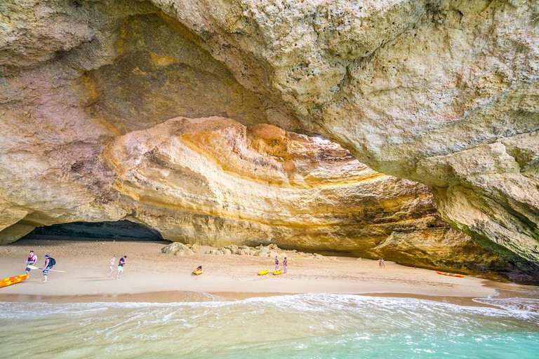 Tourist on kayaks enjoying outstanding beauty of Benagil Cave, Algarve, Portugal