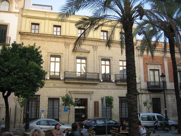 People sat outside the stone-fronted Hotel Palacio Garvey enjoying the evening