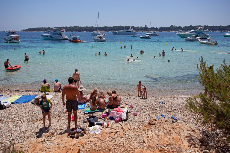 People relaxing on the beach and swimming at Ile Sainte Marguerite, Iles de Lerins, France