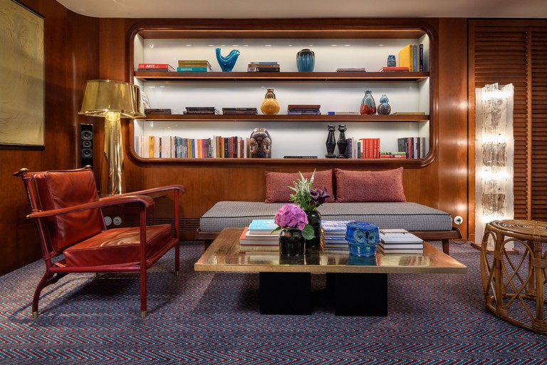 The reading area at Bairro Alto Hotel features eclectic design and a quirky bookcase
