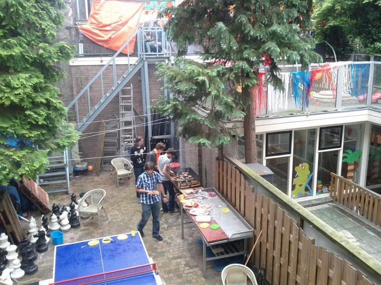 People help themselves to food at a BBQ in the garden of the Hostel B and B Utrecht City Center