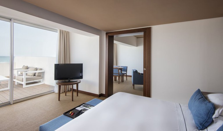 Spacious and bright double room at Tivoli Marina Vilamoura Hotel, with double doors opening up to a private balcony.