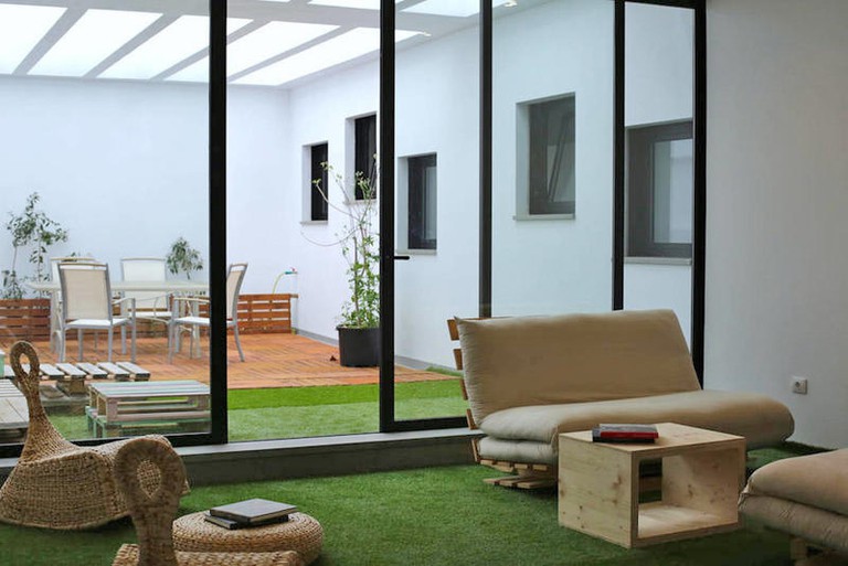Seating area at Trevejo Youth Hostel with fake grass in conservatory
