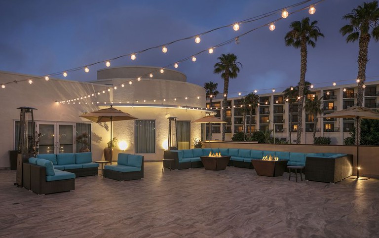 The rooftop terrace with blue cushy seating, firepits and string lights at the Redondo Beach Hotel