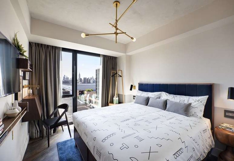 A room at The Hoxton, Williamsburg, looks out over the East River to the Mid-Town Manhattan skyline.