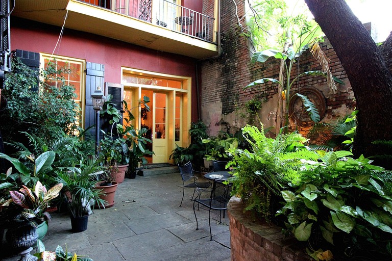 The courtyard at the Olivier House Hotel in New Orleans with plants and a table