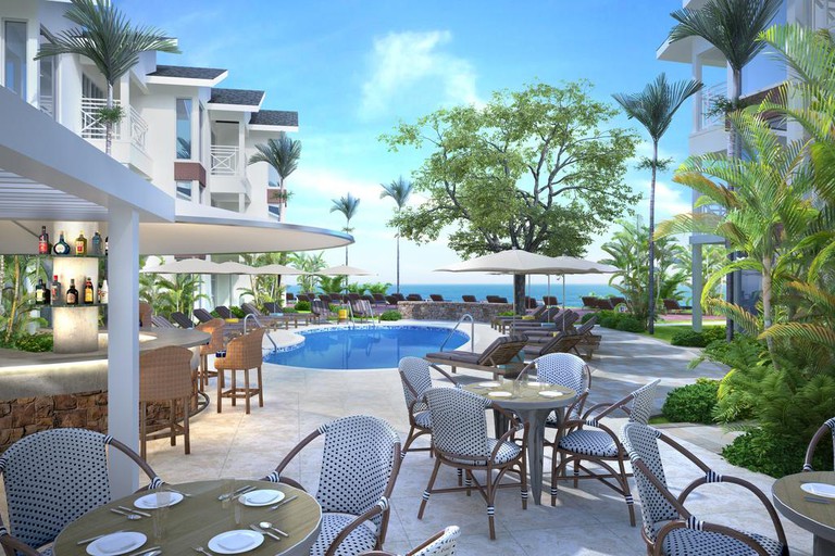 Outdoor dining area at Treasure Beach by Elegant Hotels, next to a small pool
