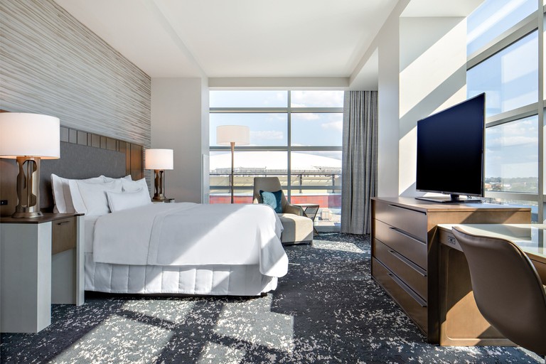 Bright king room with floor-to-ceiling windows, flatscreen TV and grey-and-white carpet at the Westin Memphis Beale Street
