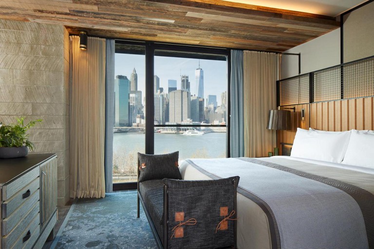 An industrial-rustic room at 1 Hotel Brooklyn Bridge, with steel and salvage wood elements and city views