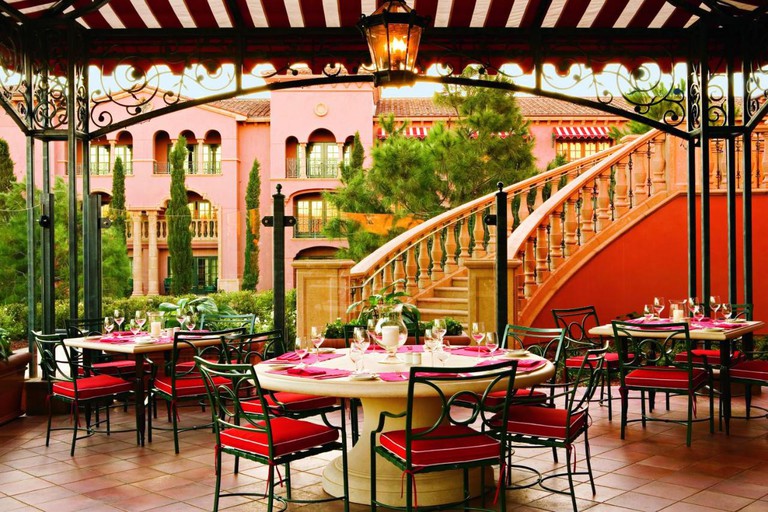 Elegant outdoor dining area in a gazebo overlooking the pink exterior of the Fairmont Grand Del Mar