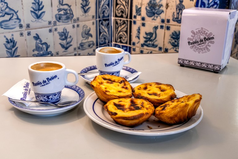 Pastel de belem or pasteis de nata custard tarts served with a cup of coffee at the historical Pasteis de Belem cafe in Belem, Lisbon, Portugal