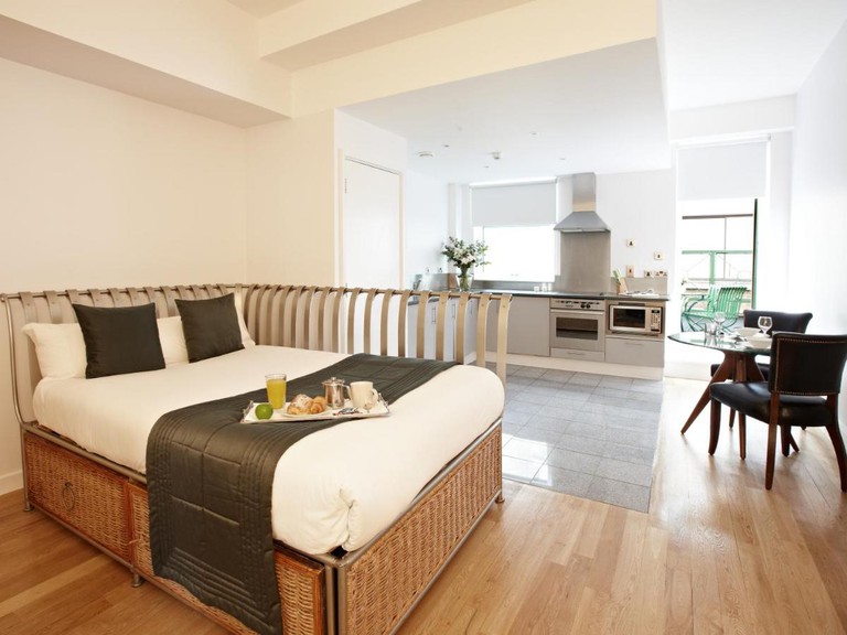 Suite interior at 196 Bishopsgate, with a full kitchen, dining table and double bed