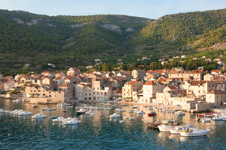 Komiža harbour on Vis is home to a small fleet of white sailing boats and encircled by attractive limestone houses.