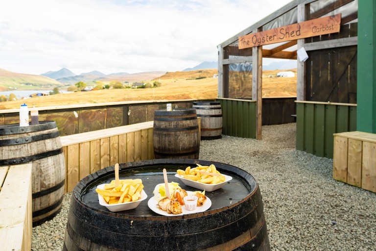 The Oyster Shed with fresh scallops and chips on whisky barrel tables,  Carbost, Highland, Isle of Skye, Scotland, UK