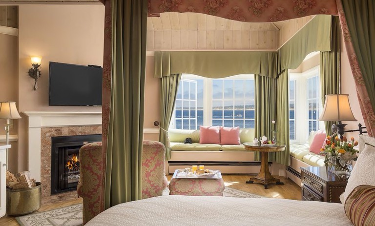 Deluxe corner view king room in soft pink and olive green colours and ocean views at Spindrift Inn