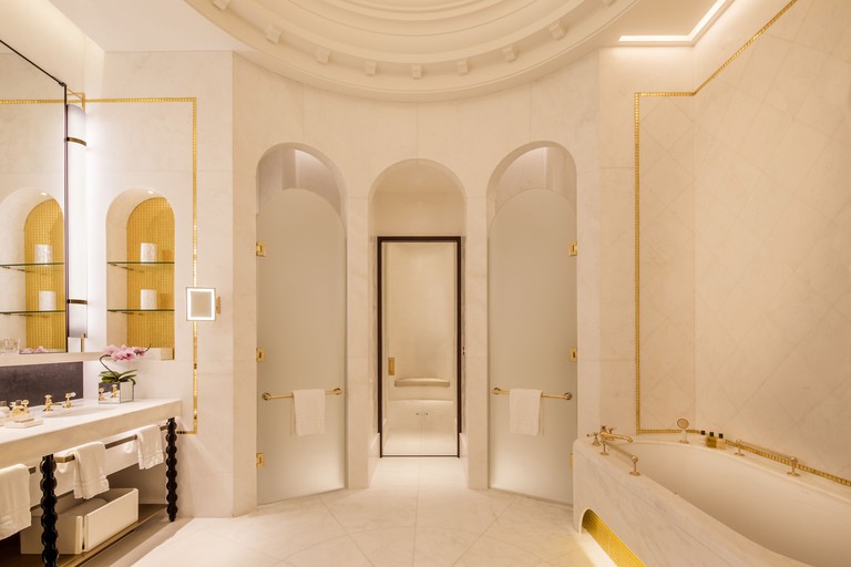 A huge and luxurious marble bathroom with tub and large vanity area at Four Seasons Hotel London.
