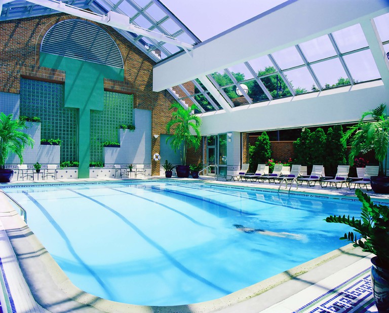 The indoor atrium-style pool with lots of greenery and loungers at Royal Sonesta Boston