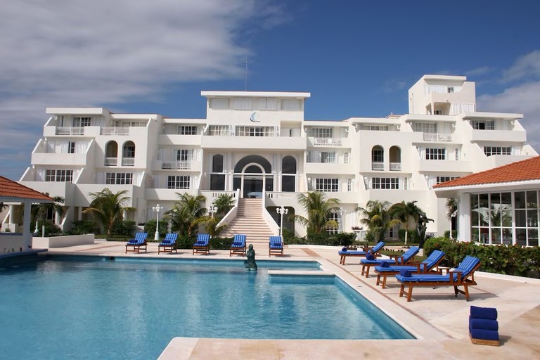 The outdoor pool and terrace leading up to the grand exterior of Casa Turquesa, Cancun.