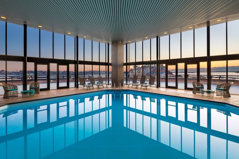 An indoor pool at Boston Marriot Long Wharf, with sun loungers and large windows