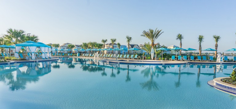 The large outdoor pool at Margaritaville Resort Orlando is surrounded by turquoise sun loungers and palm trees