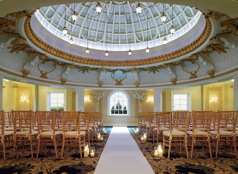An events space at the Lenox Hotel, with candles, lights hanging from a dome ceiling, chairs, carpet and windows