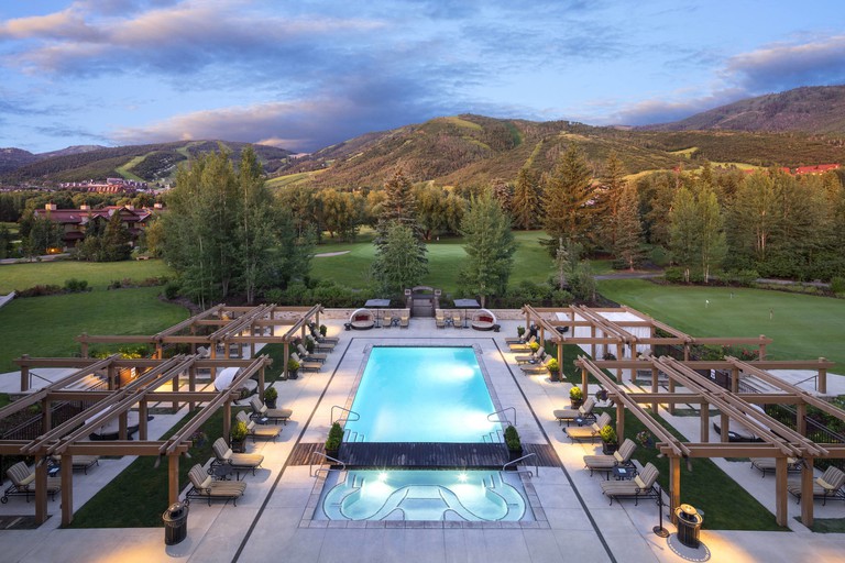Hotel Park City, Autograph Collection outdoor pool at sunset with loungers and golf course beyond