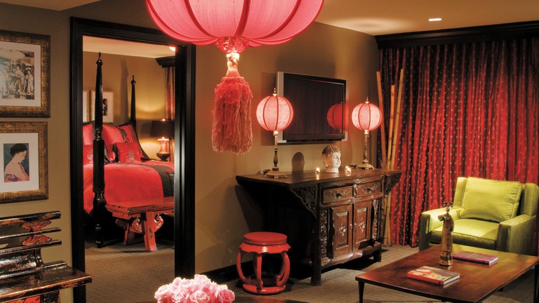 An Asian-inspired hotel with with red curtains and artwork