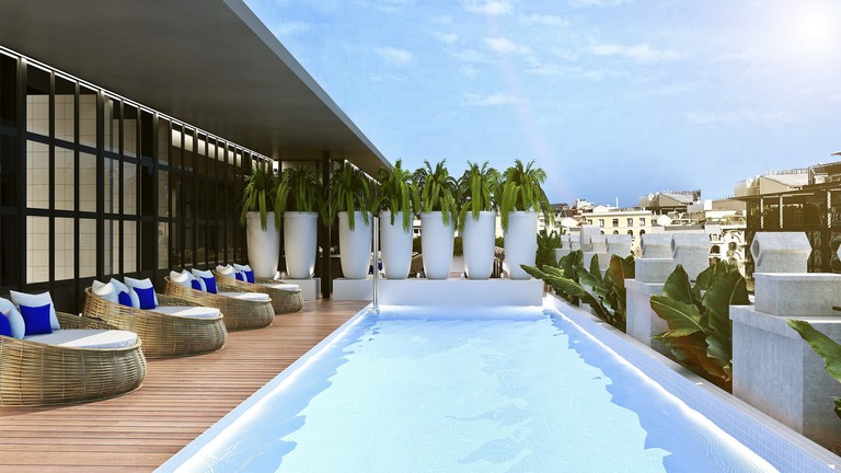 The rooftop terrace of the Monument Hotel with swimming pool, round daybeds and Mediterranean vegetation in oversized pots