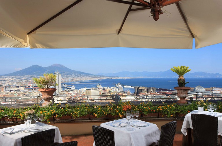 Rooftop dining area at Hotel San Francesco al Monte with views of Naples