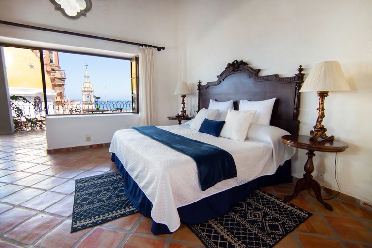 A room at Bellview Boutique Hotel with terracotta-tile floors, a double bed, and views of the Parroquia de Nuestra Señora de Guadalupe church