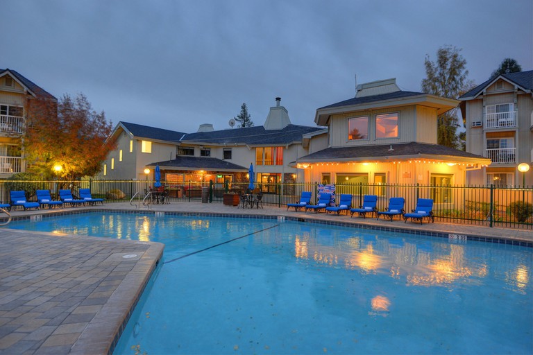 Swimming pool at Beach Retreat & Lodge at Tahoe with lit up exterior and blue sun loungers