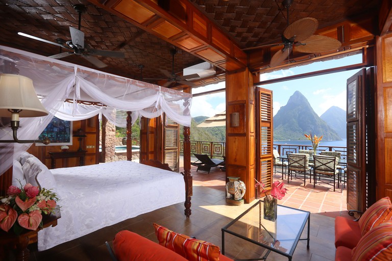Bedroom at Caille Blanc Villa & Hotel with a private terrace overlooking mountains and the ocean