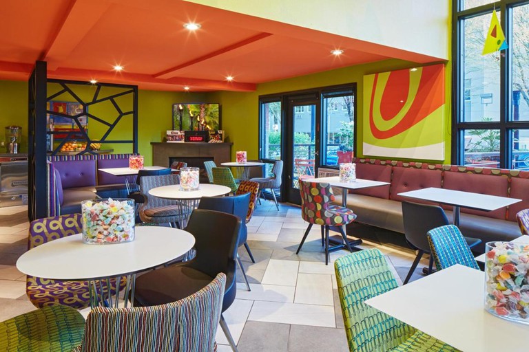 An explosion of color in the playful lobby with seating and tables topped with candy jars at Inn at Northrup Station