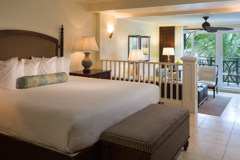 A double bed in a hotel room with seating area and a balcony at Kimpton Vero Beach Hotel & Spa