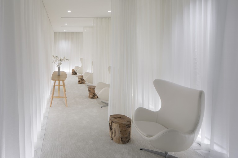 Seating area at Lotte Hotel Seattle decorated with all white furnishings