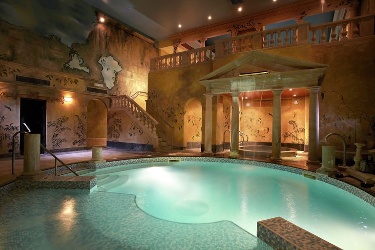 Indoor pool and spa area at Rowhill Grange Hotel, with Roman-themed decoration and tiled floors