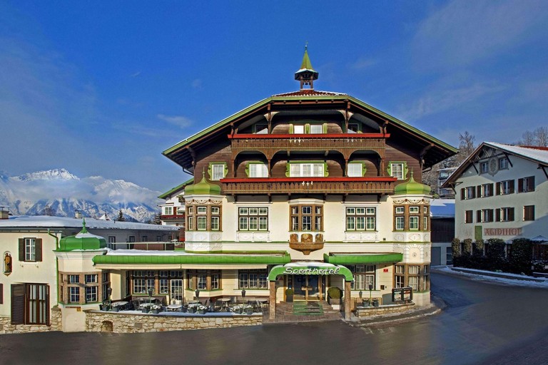 Green and white exterior with wooden balconies at Sporthotel IGLS