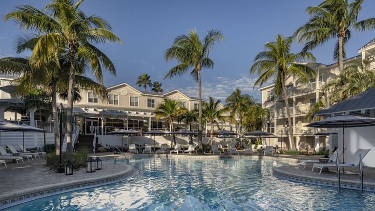 Large multiform pool and lounge chairs set amid palm trees at Margaritaville Beach House in Key West