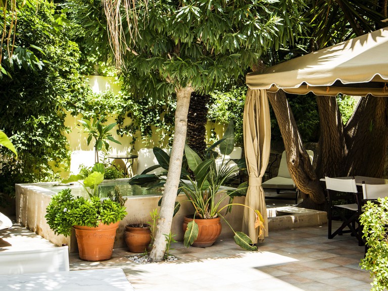 Outdoor cabana surrounded by plants and trees at Spirit of the Knights Boutique Hotel