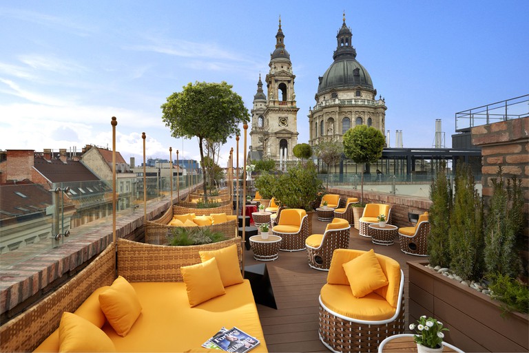 Yellow seating on the rooftop terrace at Aria Hotel Budapest by Library Hotel Collection, next to St Stephen's Basilica