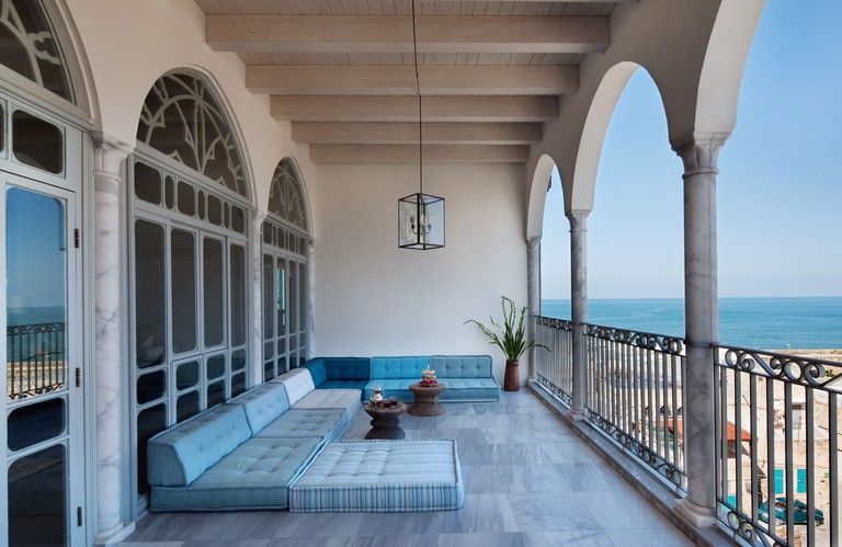 A terrace with blue sofas at The Efendi Hotel overlooking the beach and the ocean